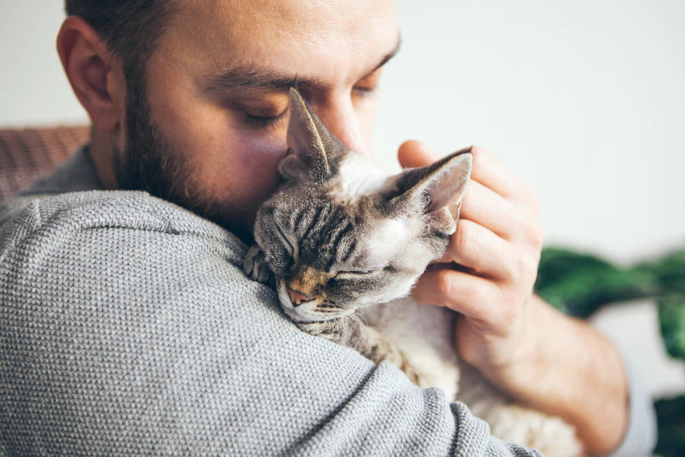 Man cuddling his cat.